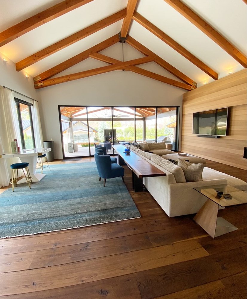The great room of a $7M custom home, staged with warm, neutral furnishings