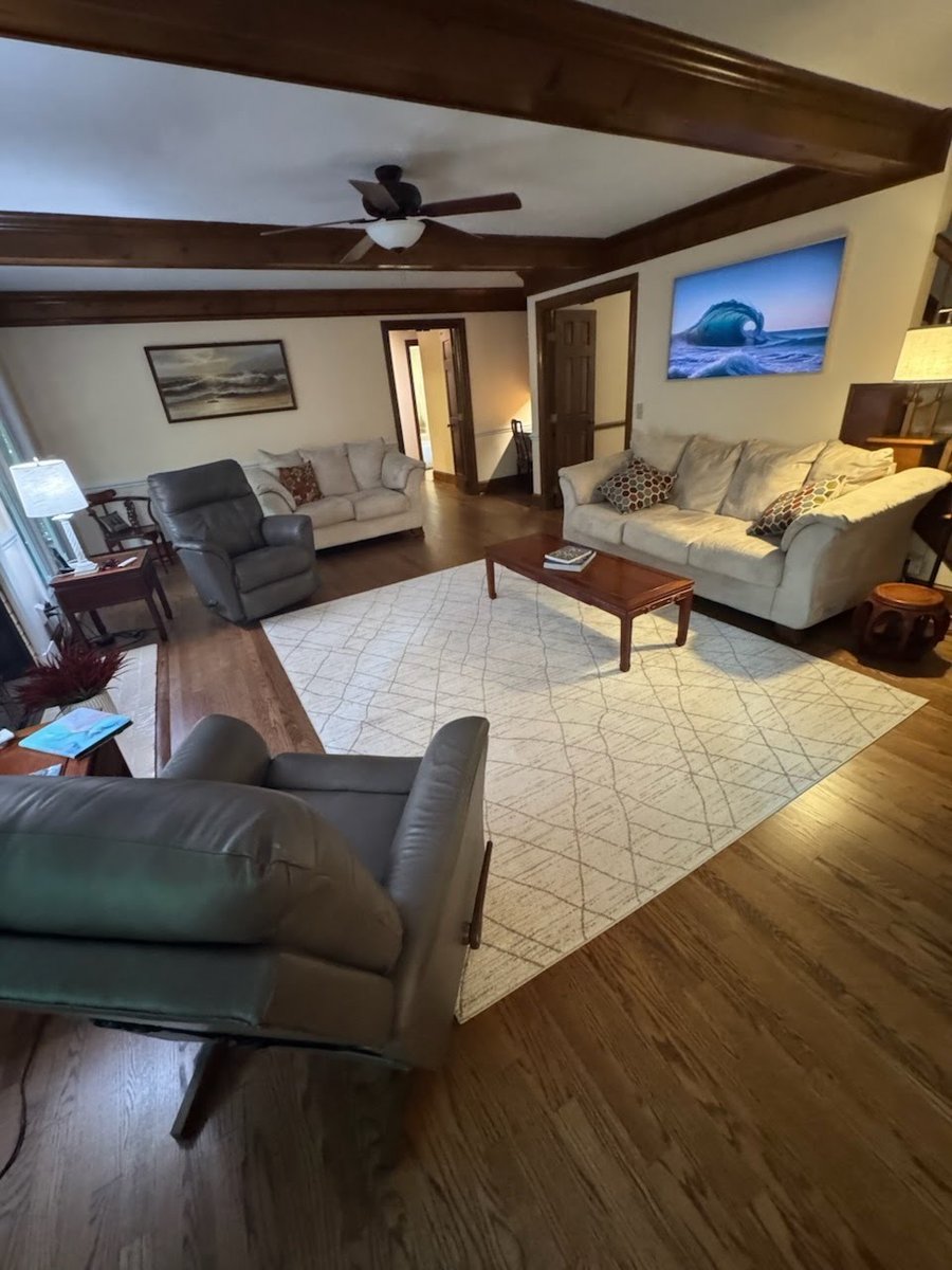 A living room with wood beams, before staging