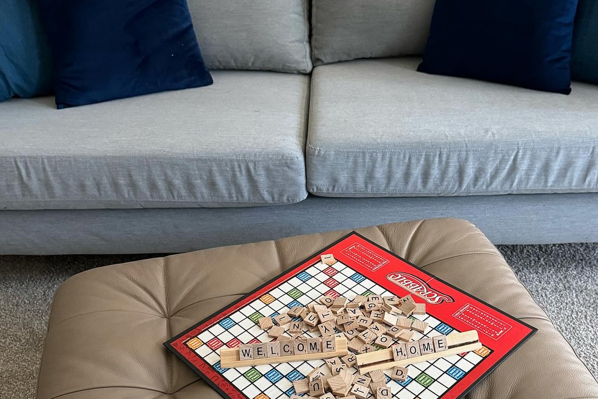 A board game styled on a leather ottoman in front of a sofa